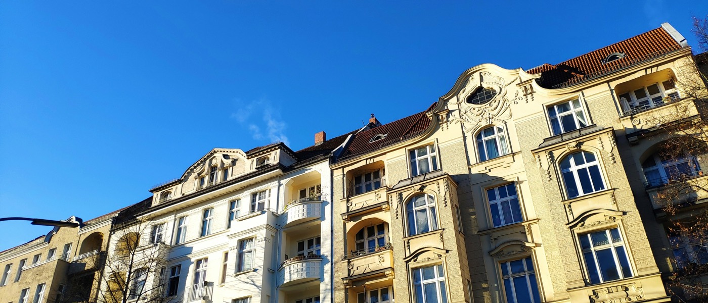 Berliner Altbaufassaden mit Stuckgiebeln vor blauem Himmel